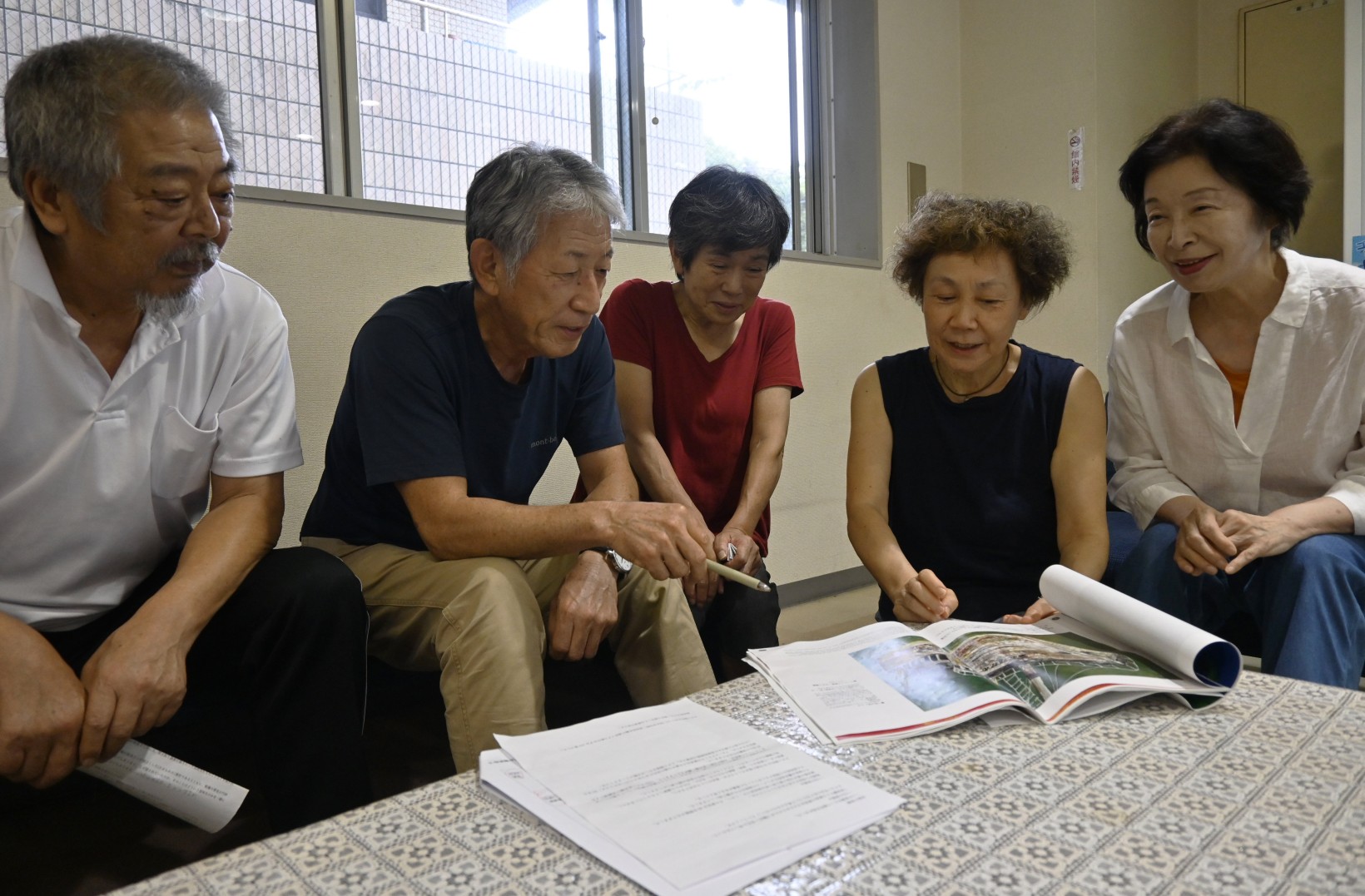 資料を見ながら、本のデザインや文章を話し合うメンバー(高知市丸ノ内2丁目の高知城ホール)