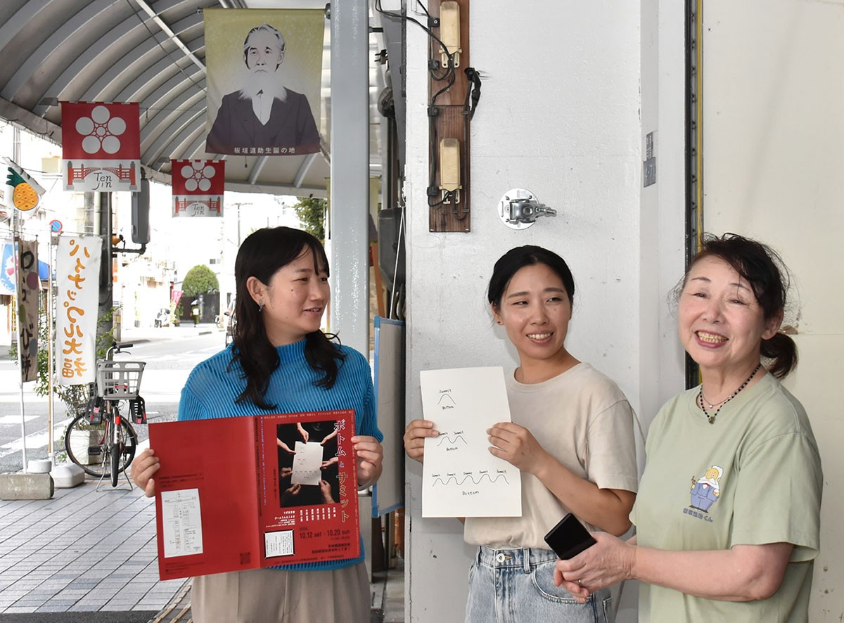 天神橋通商店街の商店主と打ち合わせする平野史恵さん=中央=と浜田明李さん=左(高知市本町3丁目)