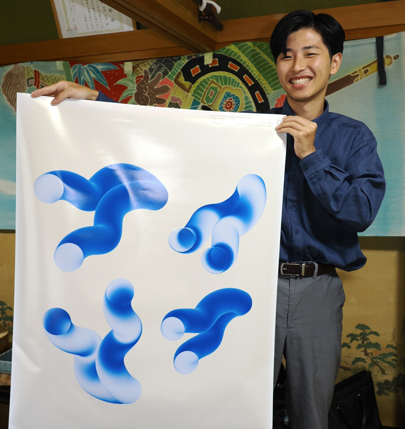 作家が宿舎にした大野見の民家で今回のポスターを紹介する高橋健悟さん（中土佐町大野見久万秋）