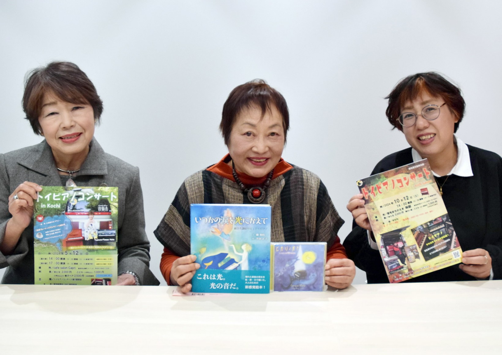コンサートのちらしなどを手にしたメンバー(高知新聞社)